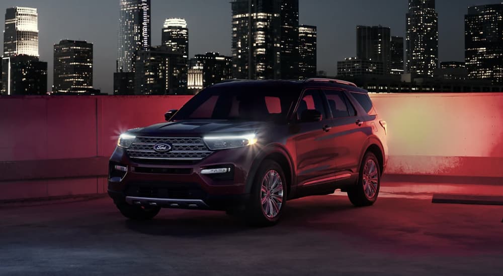 A black 2022 Ford Explorer is shown from the side parked in a city at night.
