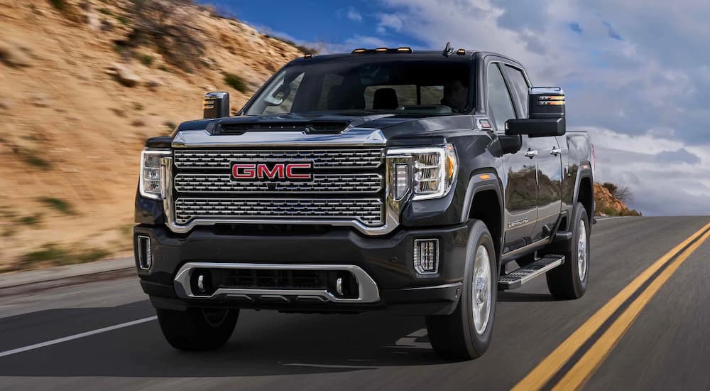 A black 2022 GMC Sierra 2500HD Denali is shown leaving a GMC dealer.