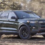 A dark green 2022 Ford Explorer Timberline is shown from the front at an angle while parked in a forest during a 2022 Ford Explorer vs 2022 Kia Sorento comparison.