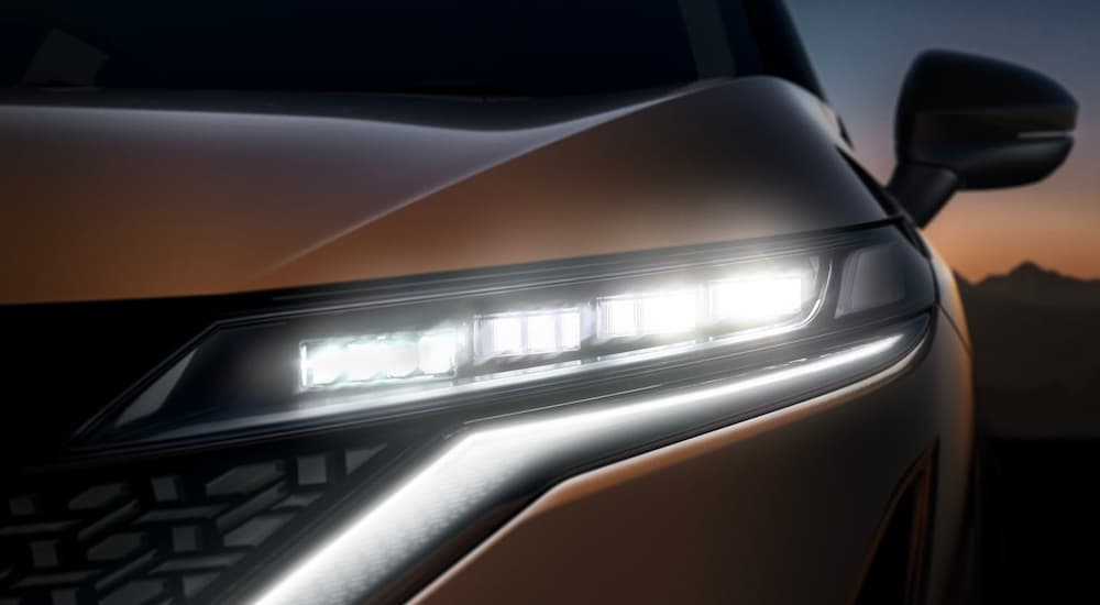 A close up shows the driver aide headlight on a bronze 2022 Nissan Ariya. 