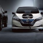 A WHITE 2022 Nissan LEAF is shown charging in a garage after visiting a Nissan dealer.