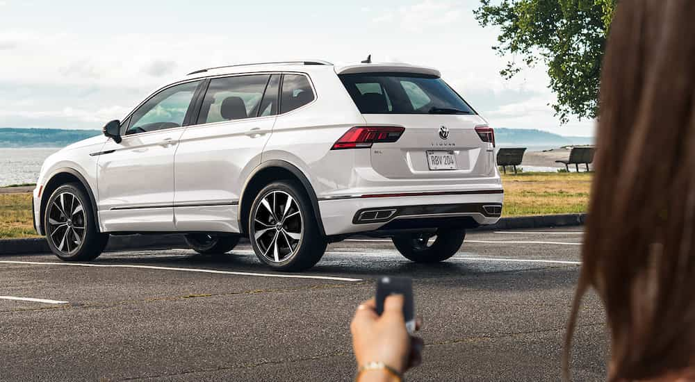 A white 2022 VW Tiguan is shown from the rear at an angle on a coastal lot.