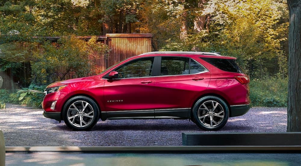 A red 2020 Chevy Equinox is shown from the side in a driveway.