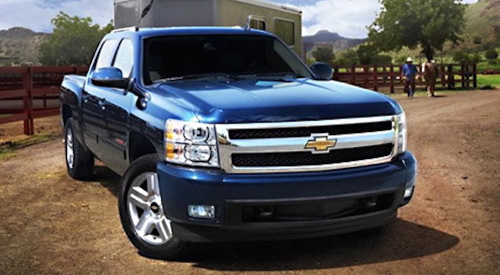 A blue 2007 Chevy Silverado 1500 is shown from the front parked on a dirt road.