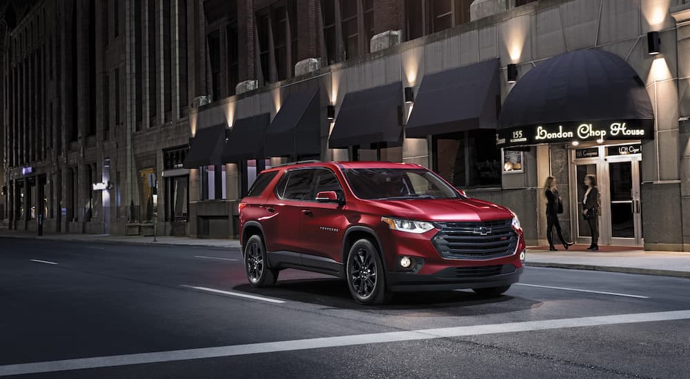A red 2023 Chevy Traverse is shown from the front at an angle on a city street.