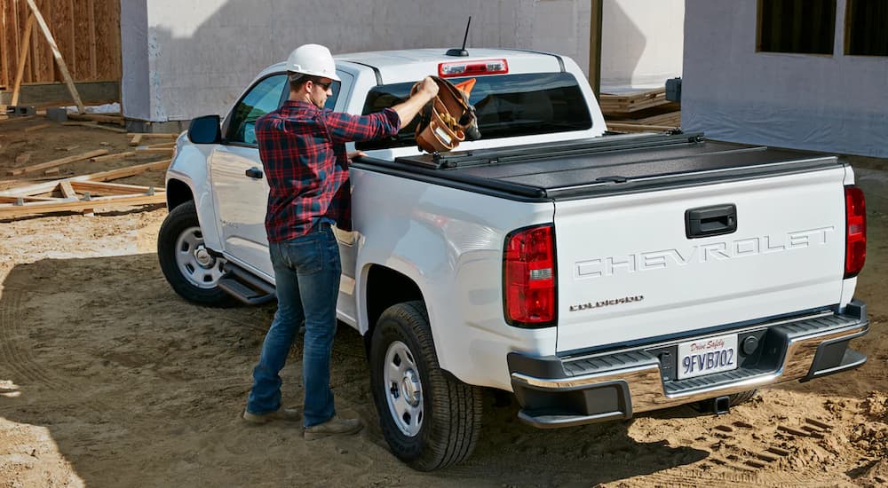 A white 2022 Chevy Colorado Commercial Truck is shown from the rear at a construction site.