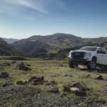 A whit e2022 GMC Canyon AT4 is shown from the front at an angle while driving off-road.