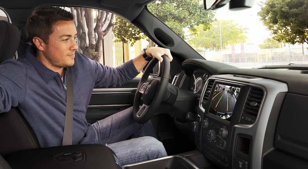 A man is shown looking at the back-up camera in a 2022 Ram 1500 Classic.