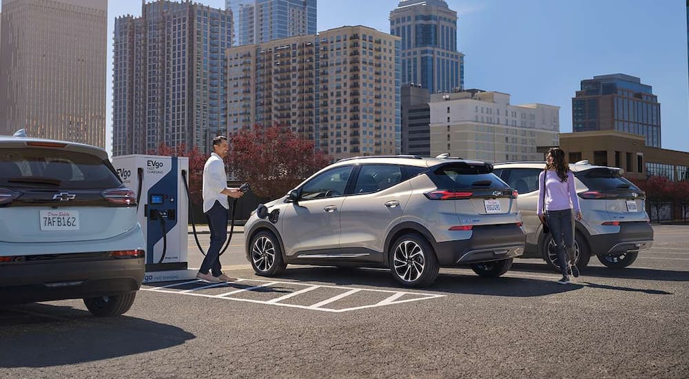 A silver 2023 Chevy Bolt EUV is shown at a charging station.