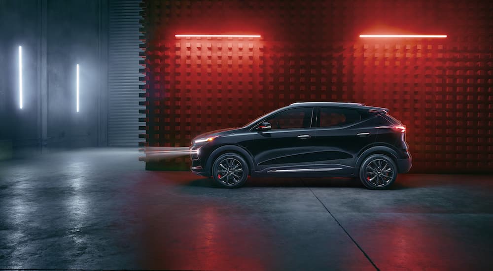 A black 2023 Chevy Bolt EUV Redline Edition is shown from the side in a modern warehouse.