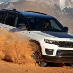 A white 2023 Jeep Grand Cherokee Two-Row is shown off-roading.