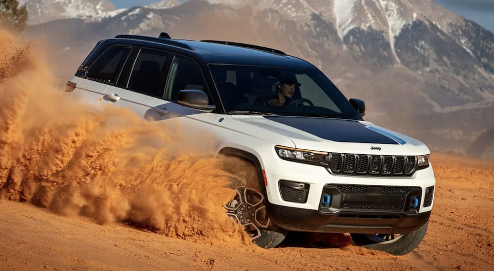 A white 2023 Jeep Grand Cherokee Two-Row is shown off-roading.