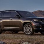 A grey 2023 Jeep Grand Cherokee three-row is shown from the side parked in a desert.