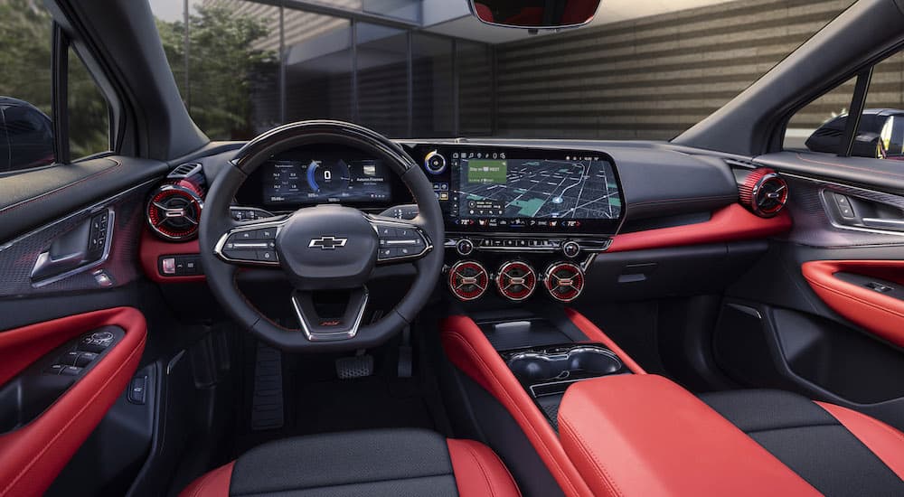 The red interior of a 2024 Chevy Blazer EV is shown from the driver's seat.