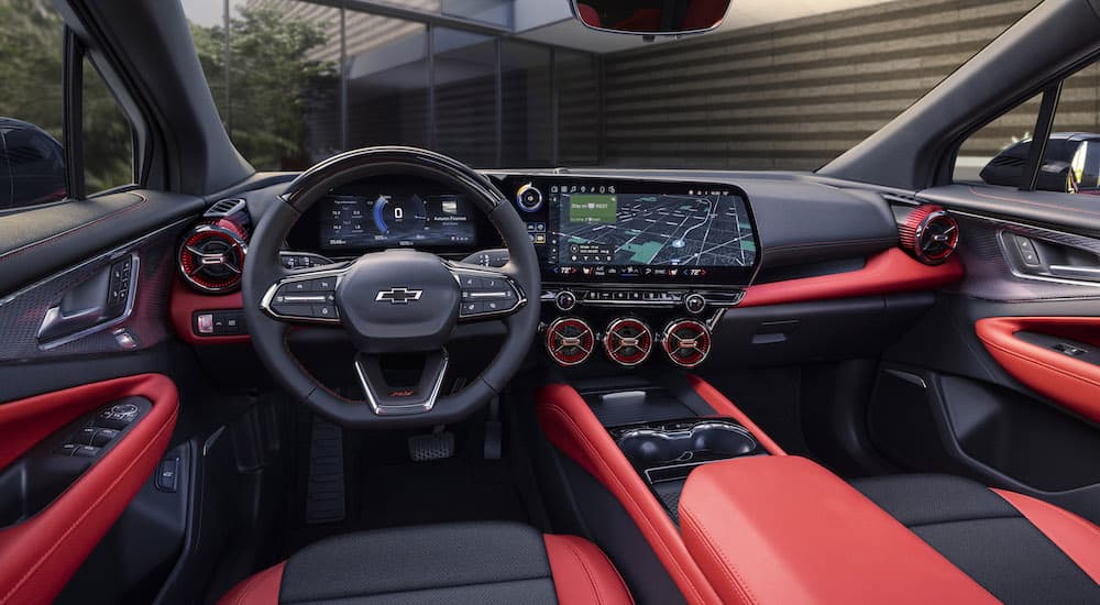 The red interior of the 2024 Chevy Blazer EV is shown from the driver's seat.