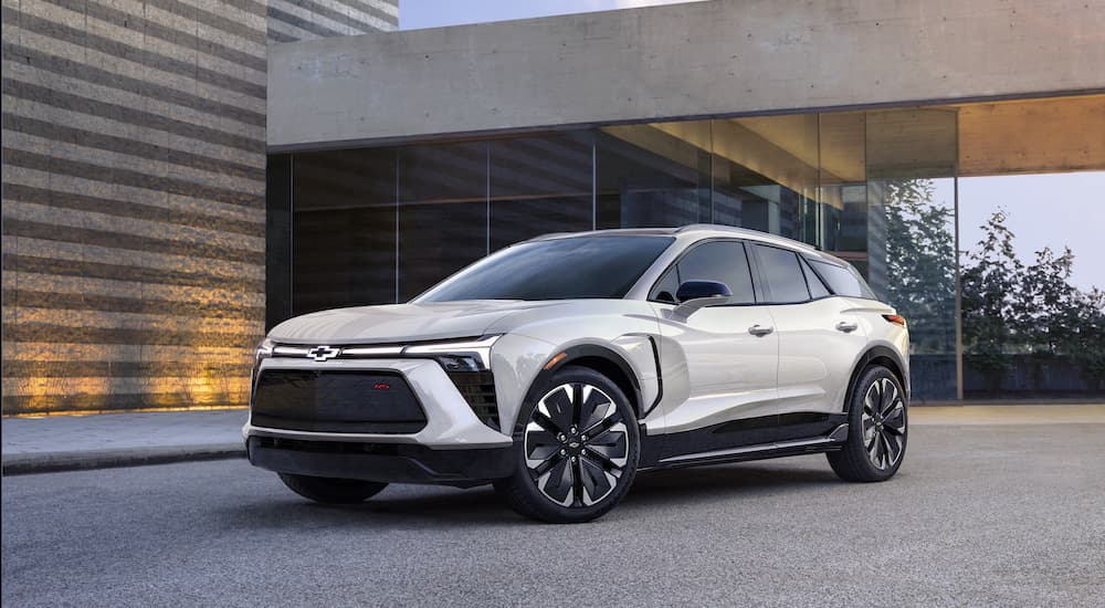 A white 2024 Chevy Blazer EV is shown from the front at an angle while parked in front of a house.