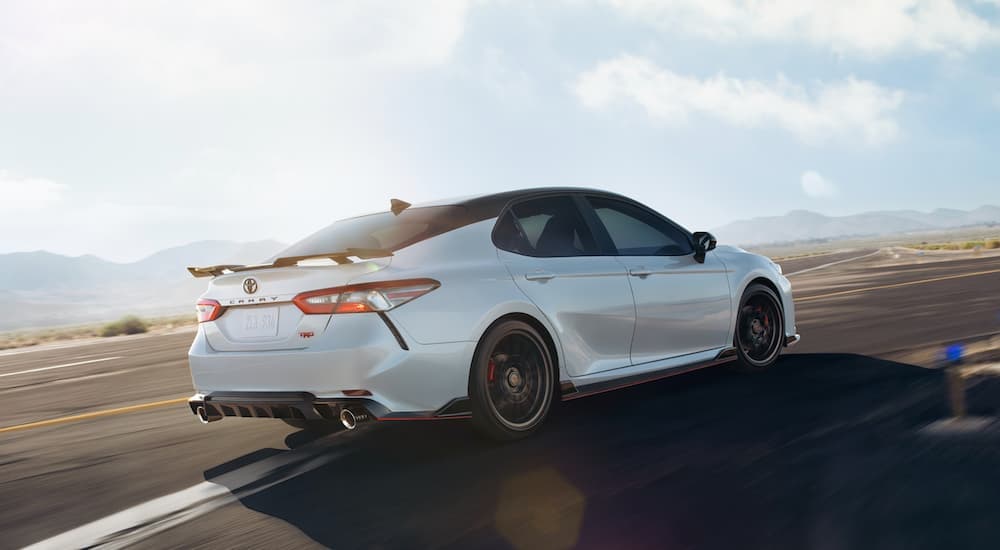 A white 2020 Toyota Camry TRD is shown driving on a track.