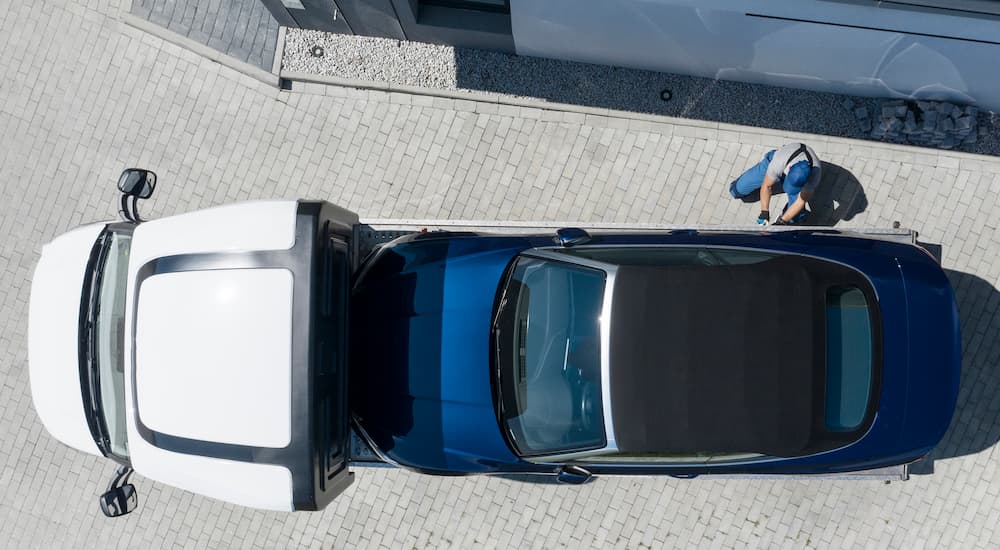 A car being repossessed is shown from a high angle.