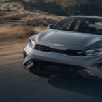 A grey 2023 Kia Forte GT is shown driving on a highway.