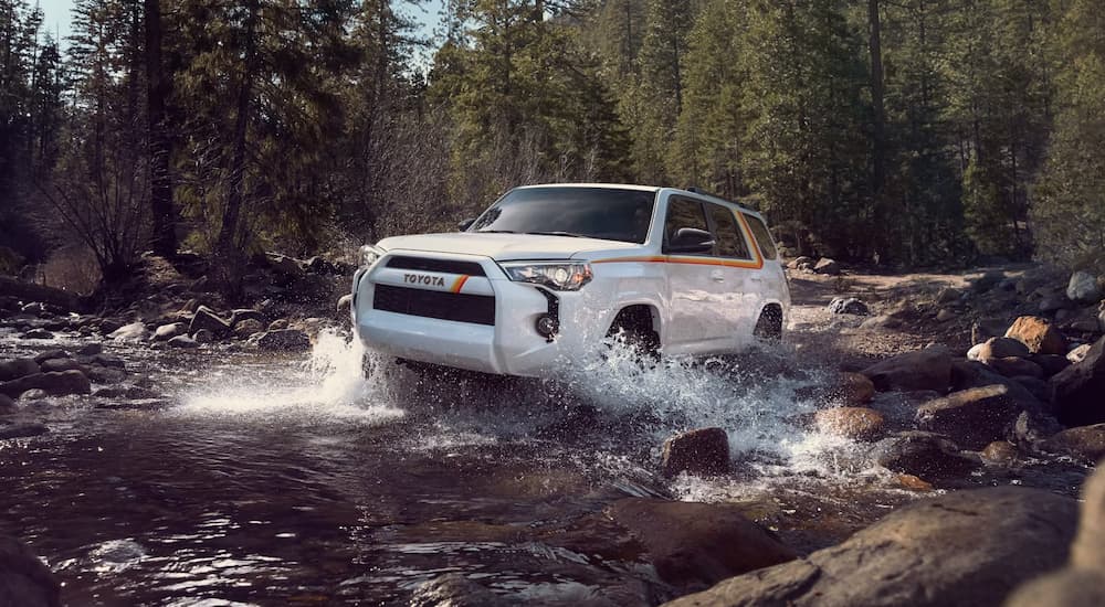 A white 2023 Toyota 4Runner 40th Anniversary Special Edition is shown driving through a river.