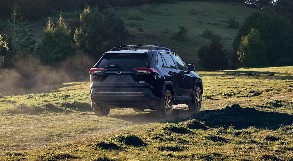 A black 2023 Toyota RAV4 Hybrid Woodland Edition is shown from the rear after leaving a Toyota dealer.