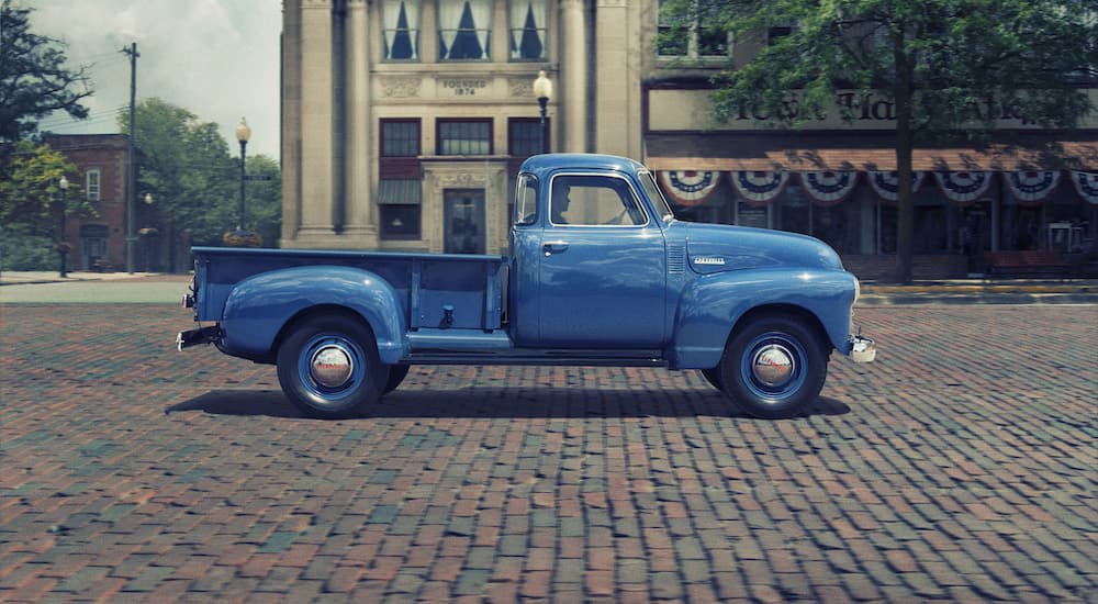 A blue 1955 Chevy 3100 is shown from the side after visiting used car dealerships. 