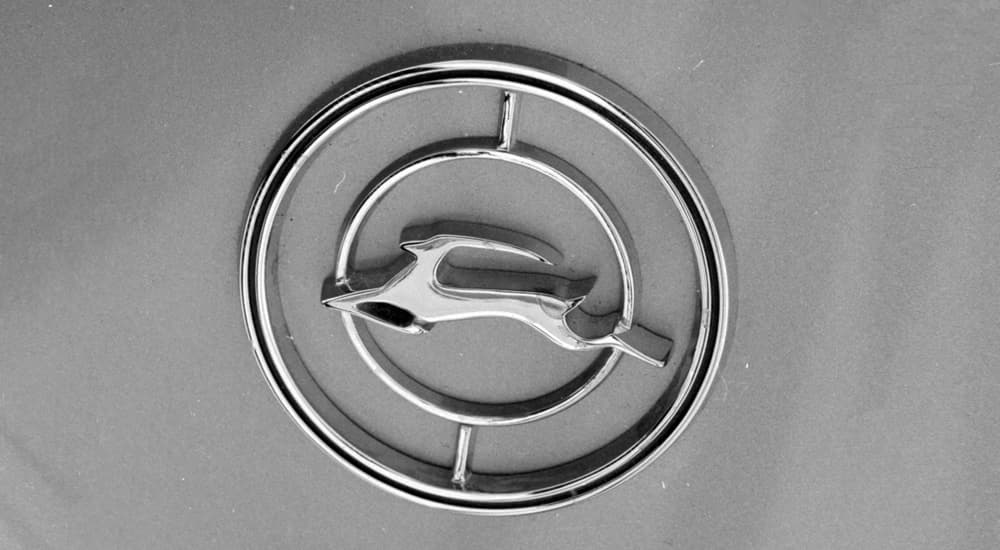 A close up shows the emblem on a 1965 Chevy Impala.