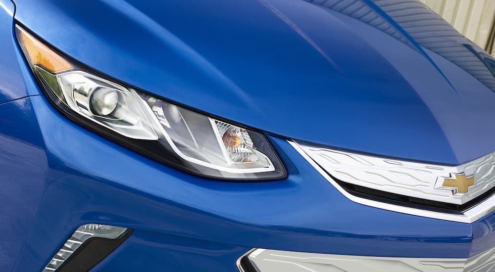 A close up shows passenger side headlight on a blue 2016 Chevy Volt.