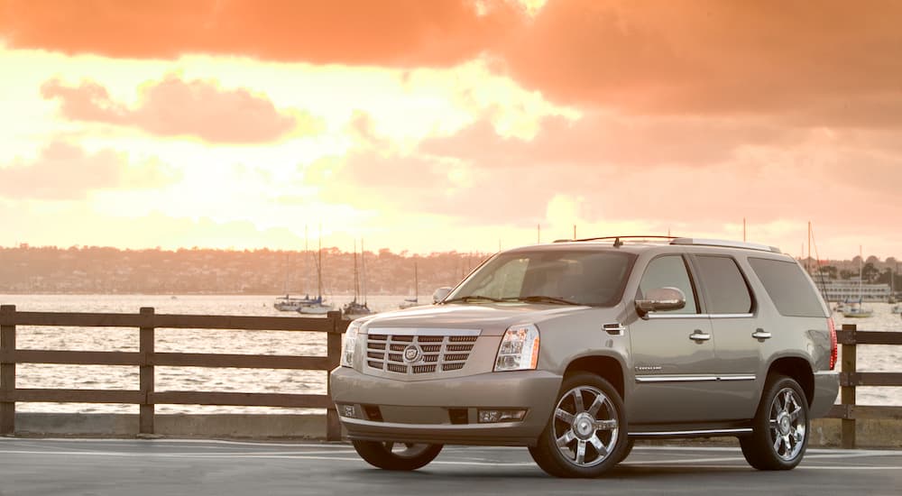 A grey 2009 Cadillac Escalade is shown from the front at an angle after leaving a used car dealership.