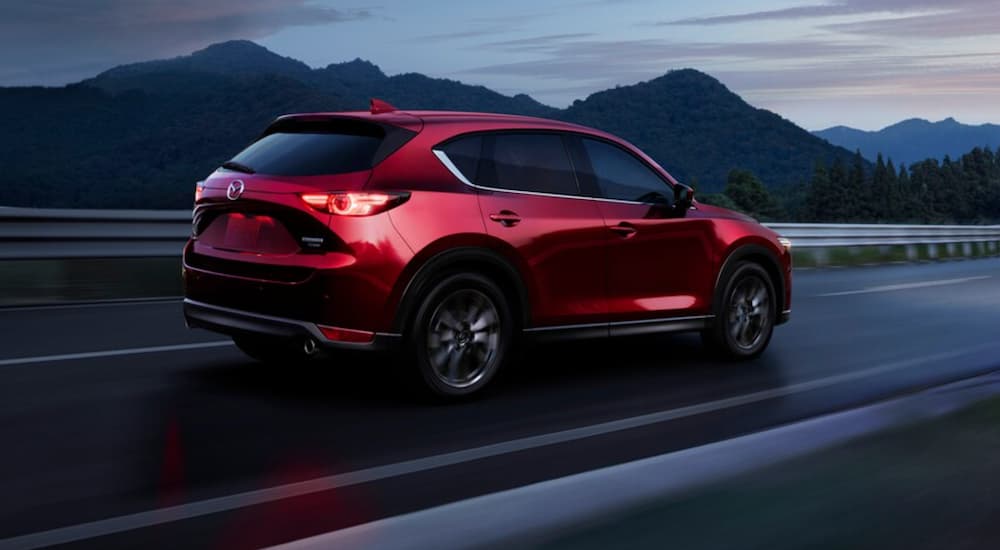 A red 2021 Mazda CX-5 is shown from the rear at an angle.