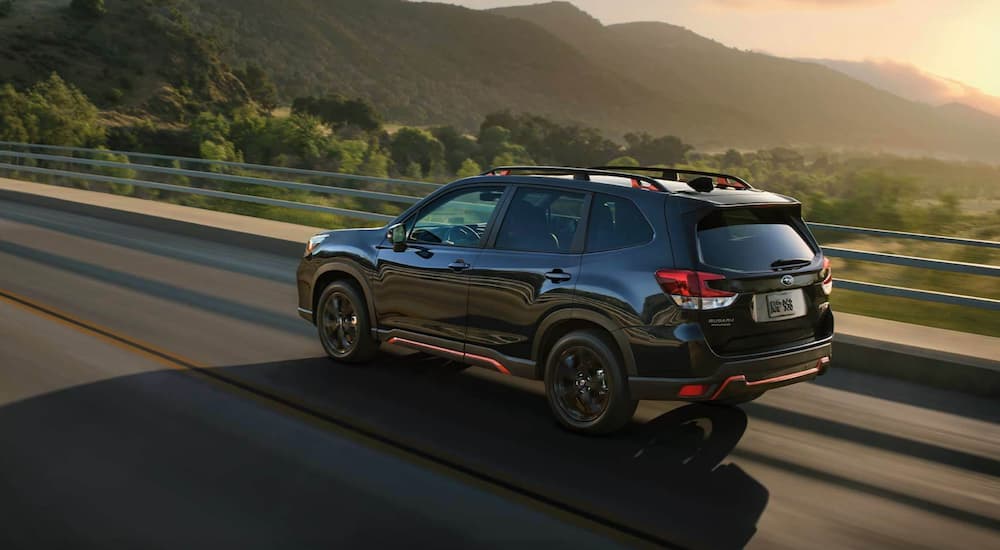 A black 2022 Subaru Forester is shown from the rear at an angle.