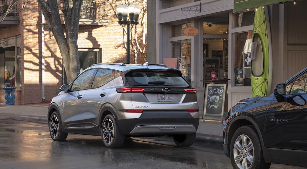 A silver 2022 Chevy Bolt EUV is shown from the rear on a city street after leaving a Chevy Bolt dealer.