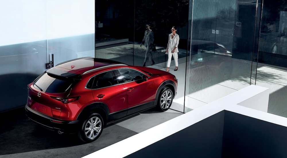 A red 2022 Mazda CX-30 is shown from a high angle in a showroom.