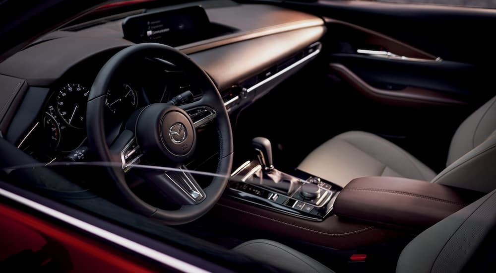 A close up shows the dash and steering wheel in red 2022 Mazda CX-30.