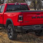 A red 2022 Ram 1500 Rebel is shown from the rear at an angle during a 2022 Ram 1500 vs 2022 Ford F-150 comparison.