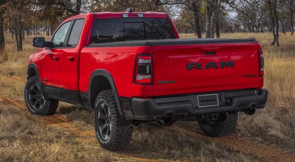 A red 2022 Ram 1500 Rebel is shown from the rear at an angle during a 2022 Ram 1500 vs 2022 Ford F-150 comparison.