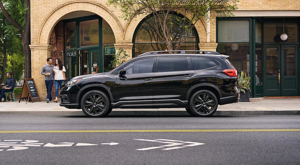 A black 2022 Subaru Ascent is shown from the side on a city street.