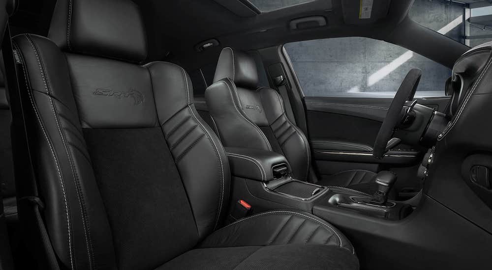 The black interior of a 2022 Dodge Charger SRT Hellcat is shown from the passenger side.