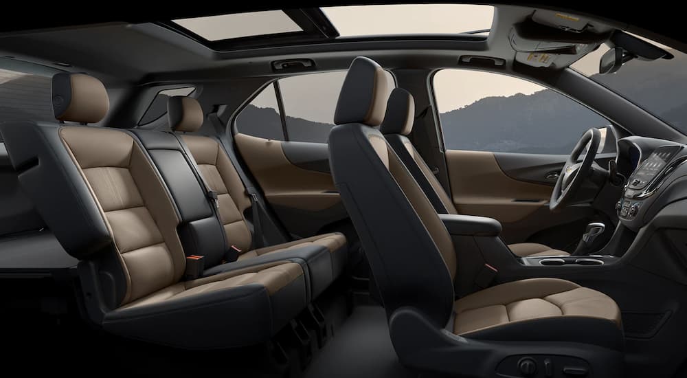 The black and tan interior of a 2023 Chevy Equinox LT shows two rows of seating.