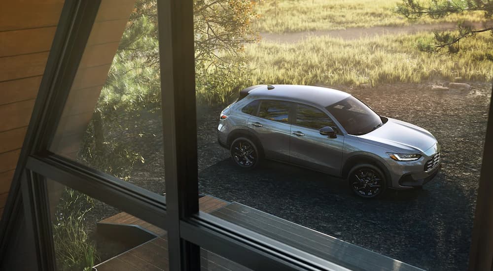 A silver 2023 Honda HR-V is shown outside of a home window.