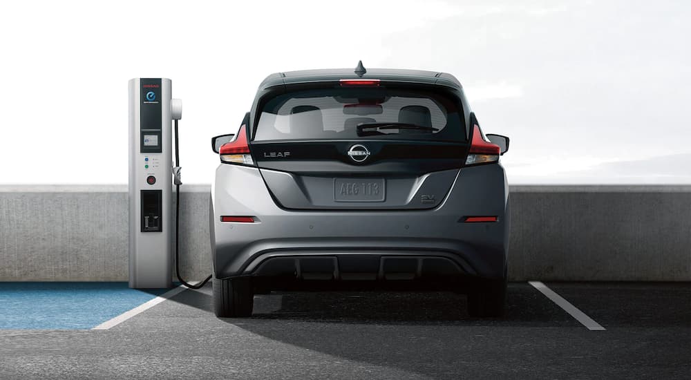 A grey 2023 Nissan LEAF SV is shown charging in a parking garage.