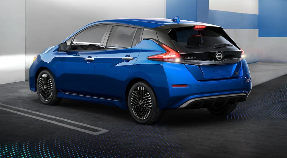 The newest Nissan LEAF for sale, a blue 2023 Nissan LEAF SV, is shown reversing with simulated sensor lines.