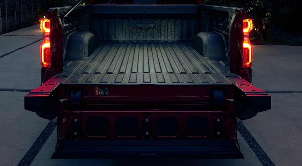 The open tailgate of a red 2022 Chevy Silverado 1500 RST is shown at a Chevy Silverado 1500 dealer.