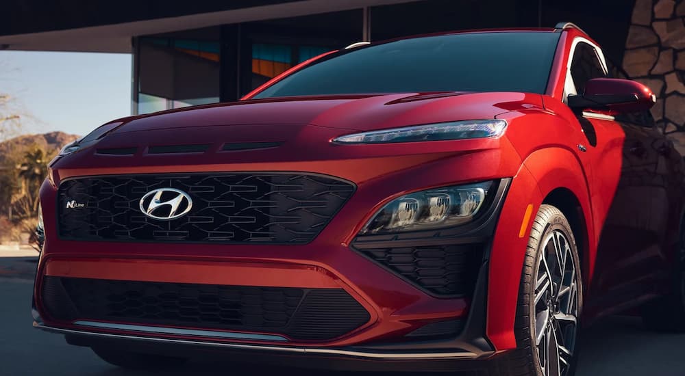 A red 2023 Hyundai Kona N-Line is shown parked in a home driveway.