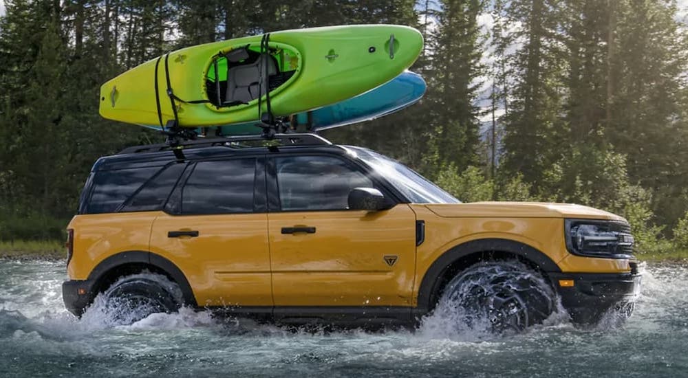 A yellow 2021 Ford Bronco Sport is shown from the side during a 2022 Ford Bronco Sport vs 2022 Volkswagen Taos comparison.