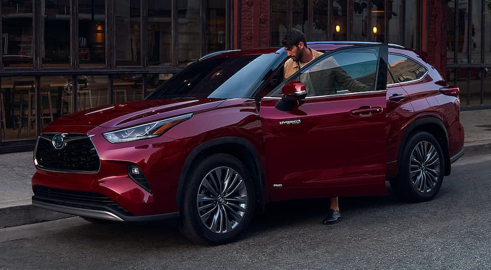 A red 2020 Toyota Highlander for sale is shown parked on a city street.