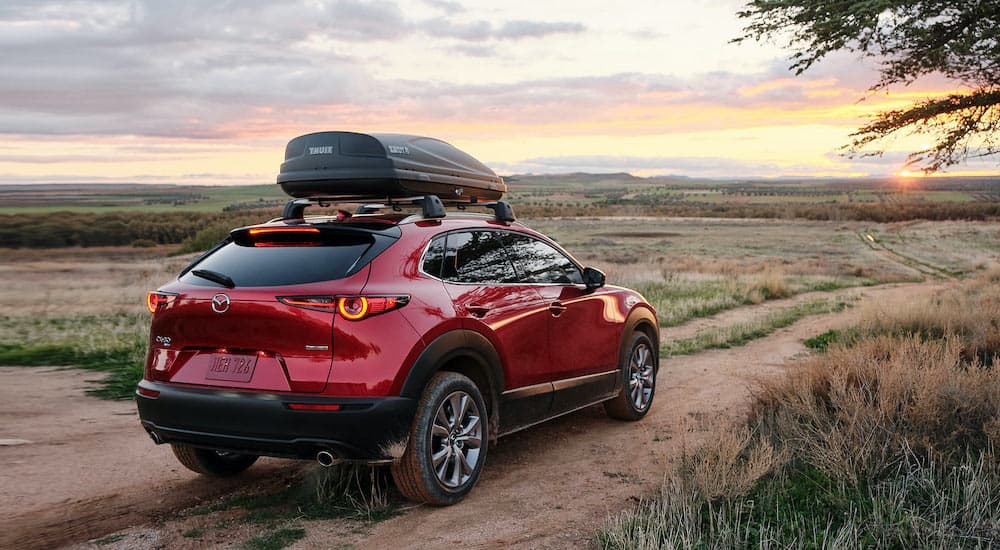 A red 2021 Mazda CX-30 is shown from the rear on a trail.