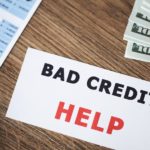 A notecard that says 'bad credit help' is shown on a table.