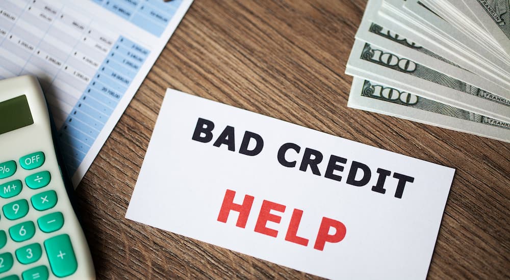 A notecard that says 'bad credit help' is shown on a table.