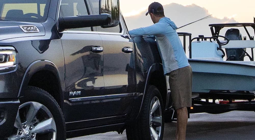 A grey 2022 Ram 1500 is shown from the front while being loaded with fishing equipment.